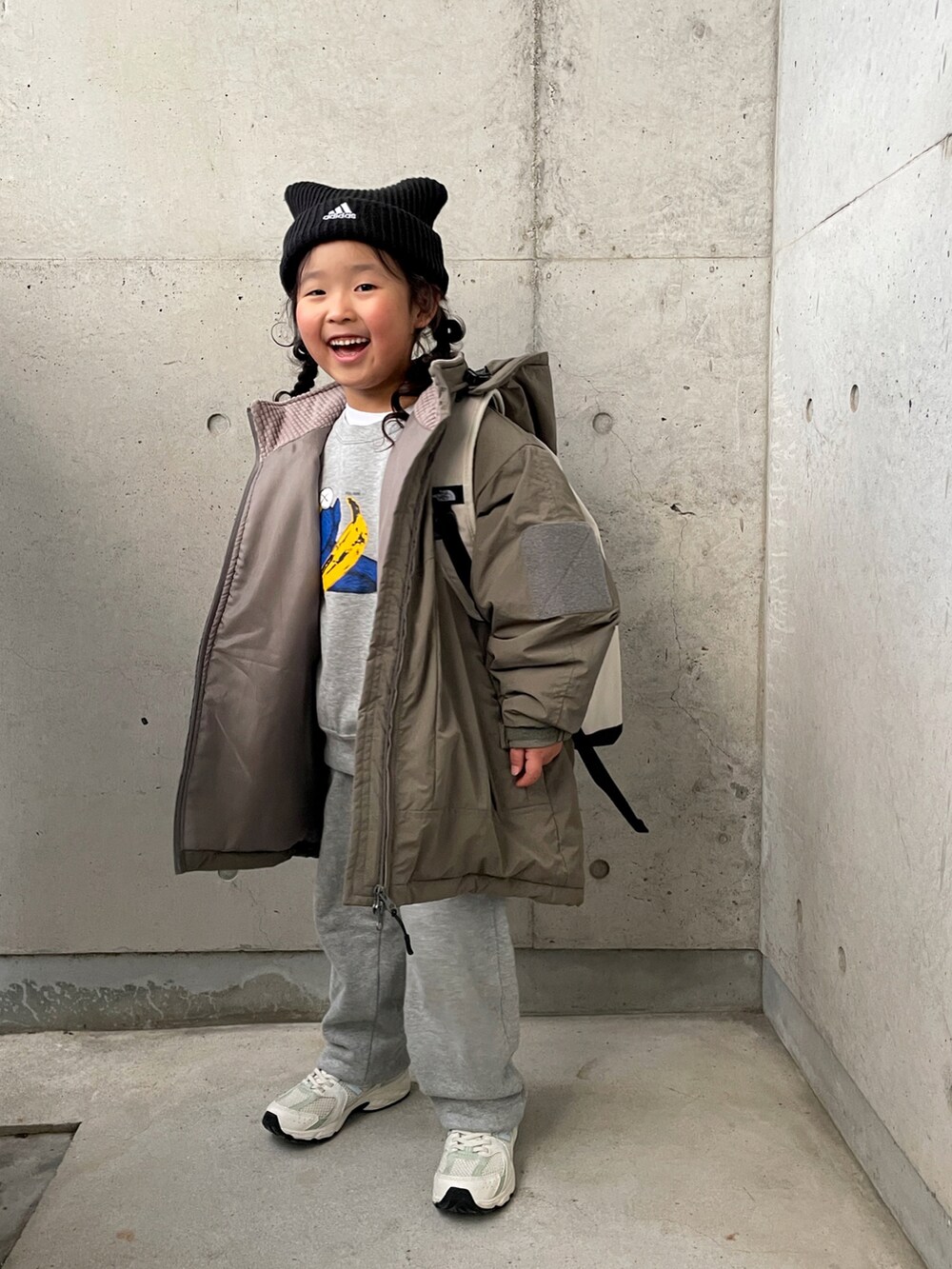 グリーン系のブルゾン、ホワイト系のバックパック/リュック、グレー系のパンツを着用したキッズの冬コーディネートの3枚目の写真