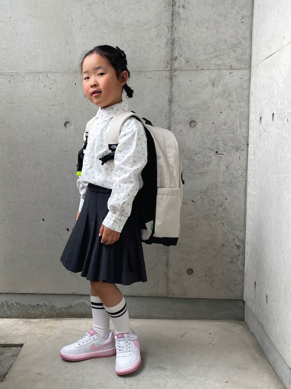 ホワイト系のスニーカー、グレー系のスカート、ホワイト系のシャツ/ブラウスを着用したキッズの春コーディネートの3枚目の写真