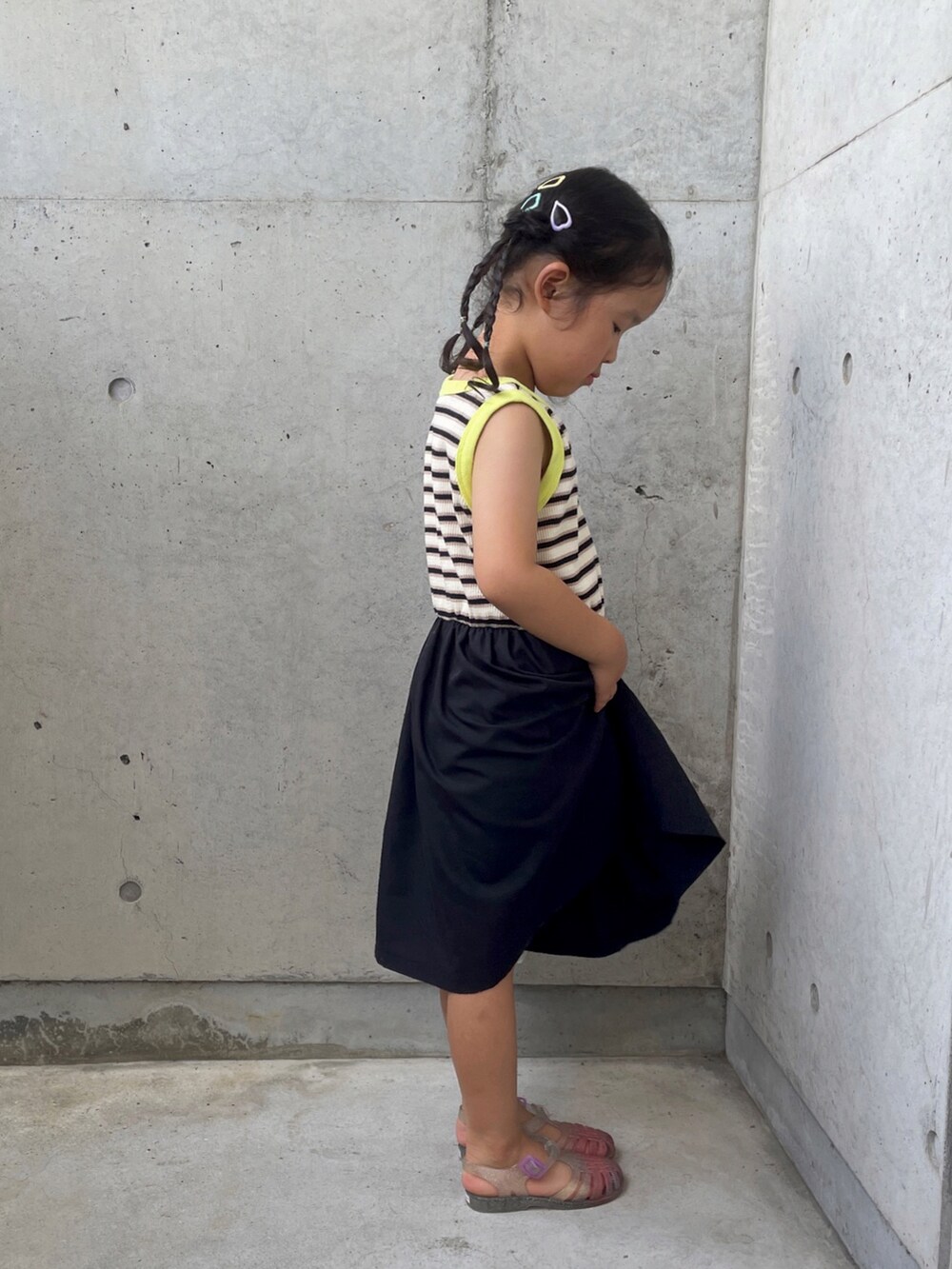 ホワイト系のサンダル、ブラック系のワンピース、シルバー系のハンドバッグを着用したキッズの夏コーディネートの4枚目の写真