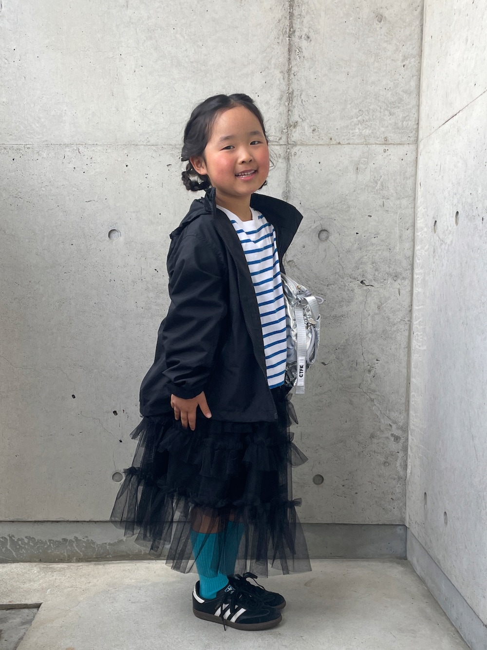 ブラック系のスニーカー、シルバー系のショルダーバッグ、ブルー系のTシャツ/カットソーを着用したキッズの春コーディネートの3枚目の写真