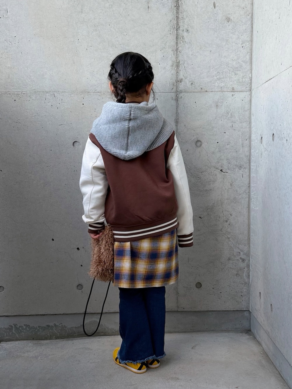 ブルー系のデニムパンツ、イエロー系のワンピース、イエロー系のスニーカーを着用したキッズの冬コーディネートの3枚目の写真