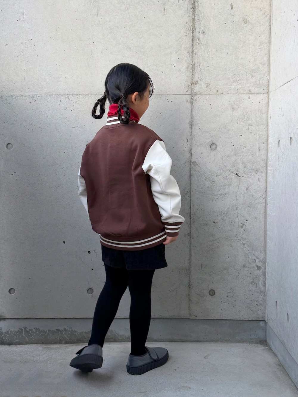 レッド系のニット/セーター、ブラック系のその他パンツ、グレー系のその他シューズを着用したキッズの冬コーディネートの2枚目の写真