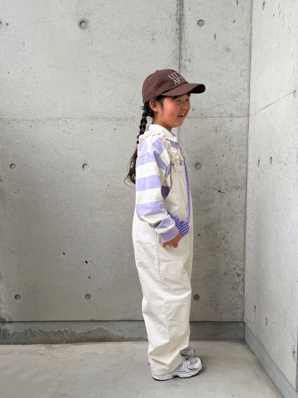 パープル系のTシャツ/カットソー、ホワイト系のサロペット/オーバーオール、ホワイト系のスニーカーを着用したキッズの春コーディネートの5枚目の写真