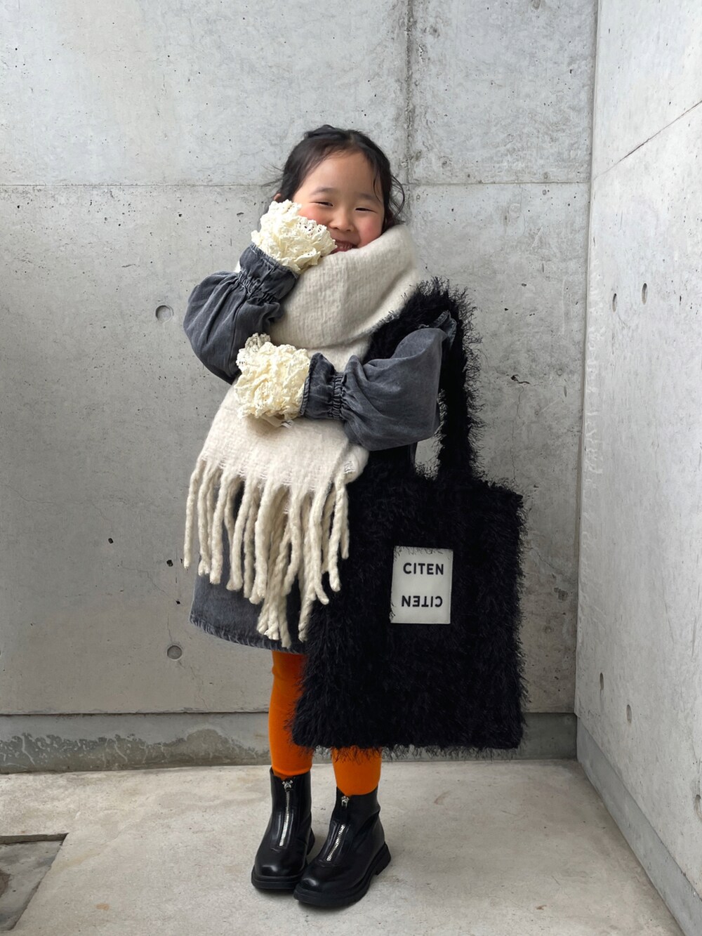 ホワイト系のTシャツ/カットソー、ブラック系のトートバッグ、グレー系のワンピースを着用したキッズの冬コーディネートの3枚目の写真