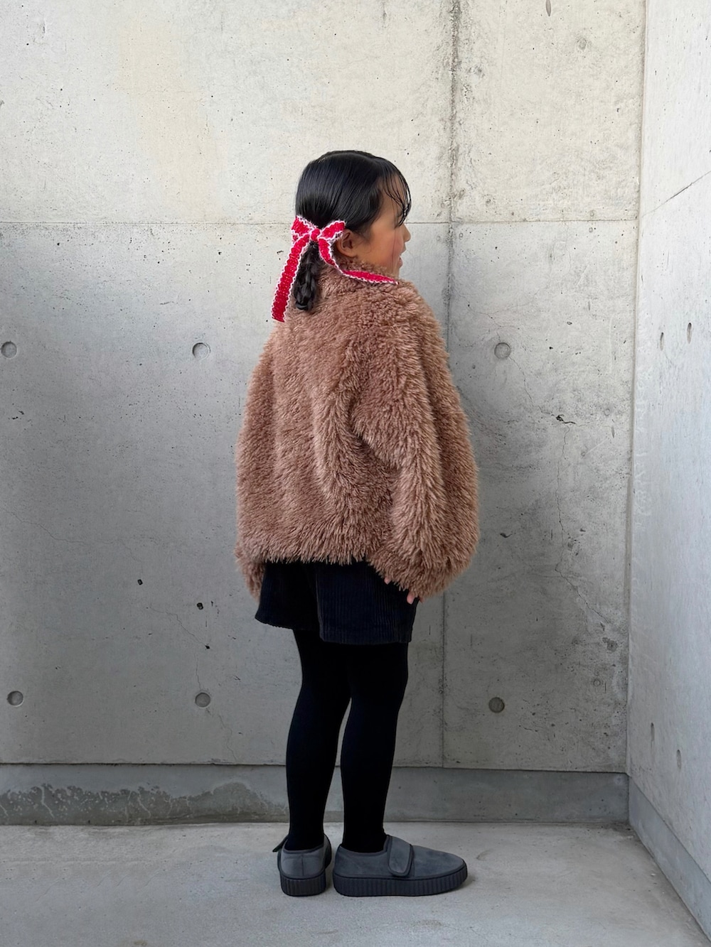 レッド系のニット/セーター、ブラック系のその他パンツ、ブラウン系のブルゾンを着用したキッズの冬コーディネートの2枚目の写真