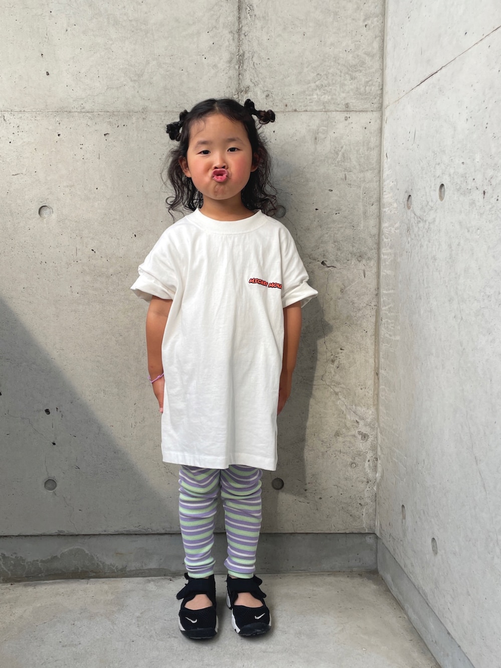 ホワイト系のTシャツ/カットソー、ブラック系のスニーカー、パープル系のレギンス/スパッツを着用したキッズの春コーディネートの2枚目の写真