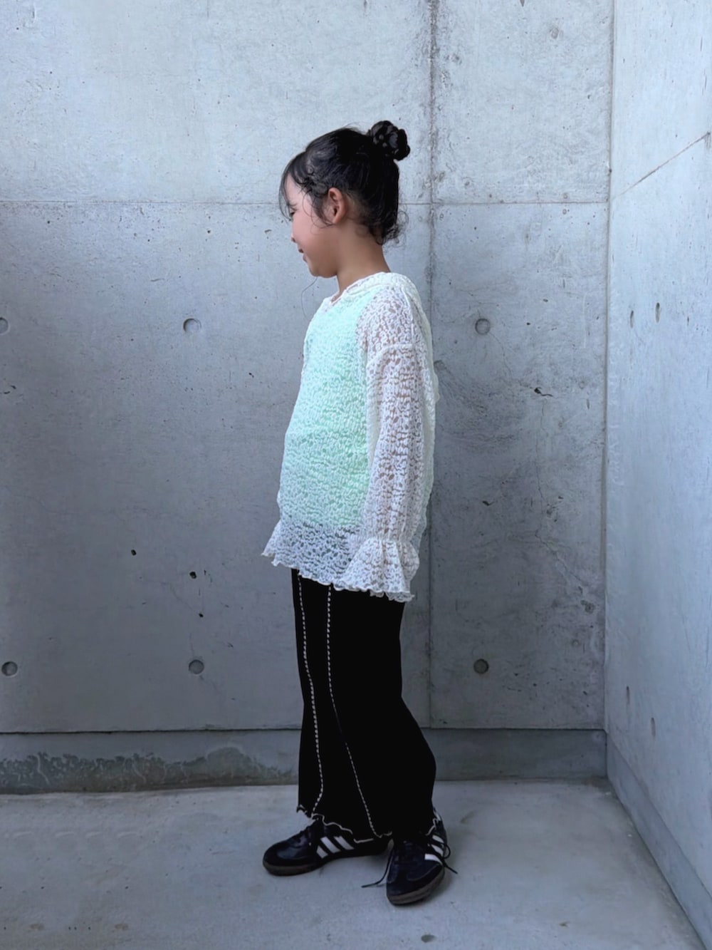 ブラウン系のダウンジャケット/コート、ブラック系のスニーカー、ホワイト系のTシャツ/カットソーを着用したキッズの秋コーディネートの4枚目の写真