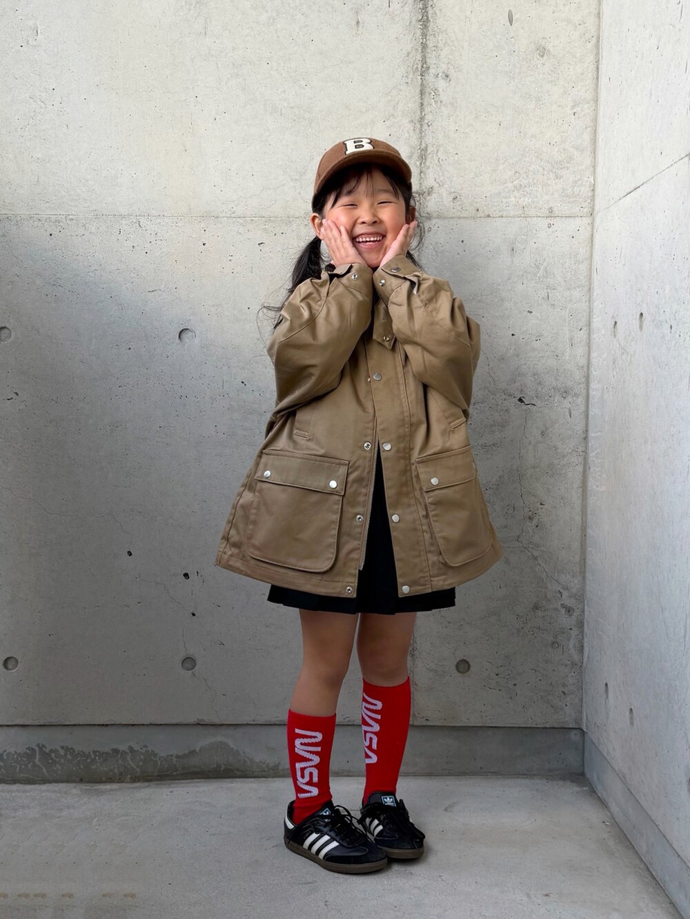 ブラック系のスニーカー、ホワイト系のTシャツ/カットソー、ベージュ系のミリタリージャケットを着用したキッズの秋コーディネートの3枚目の写真