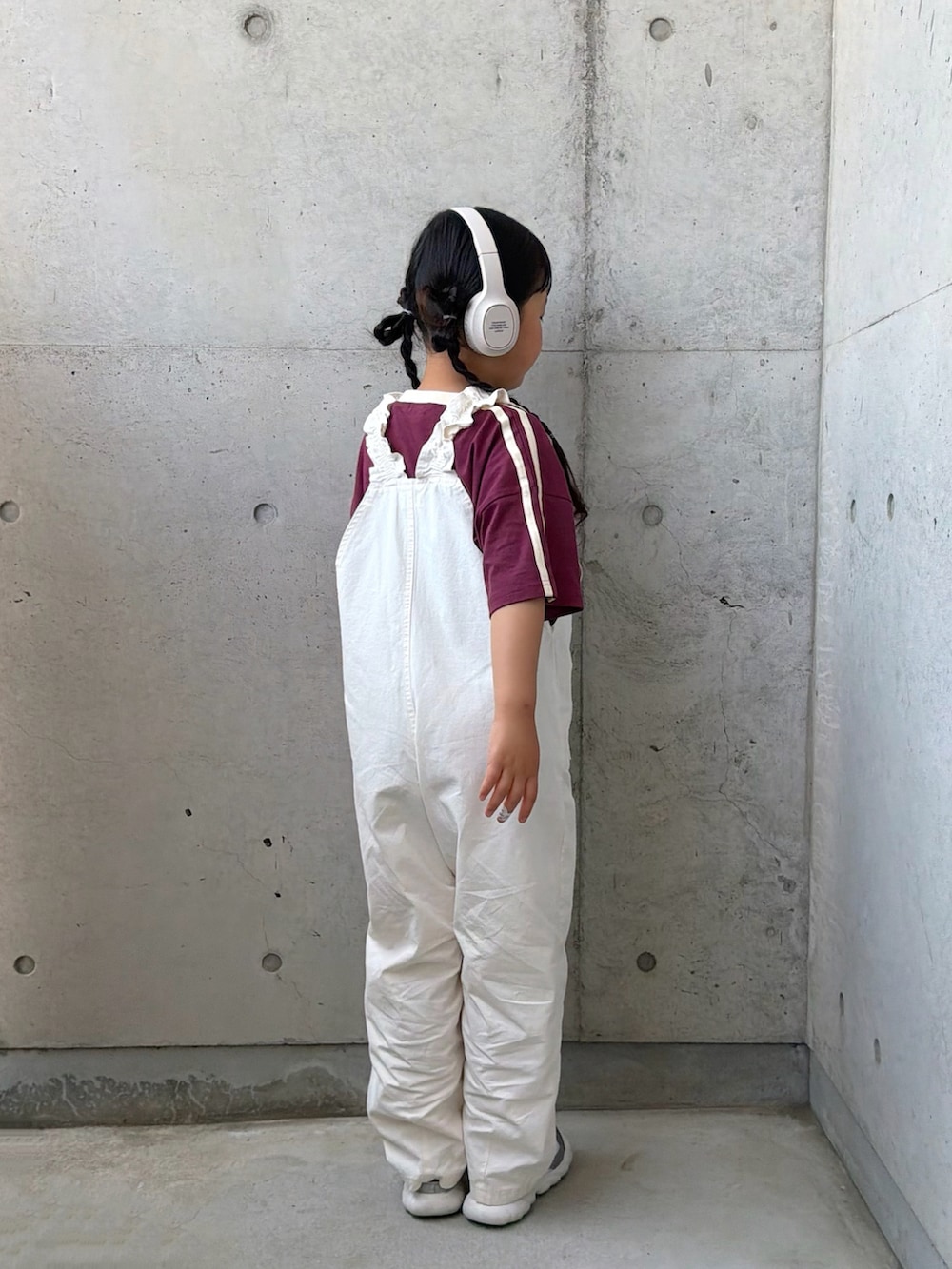 ホワイト系のサロペット/オーバーオール、レッド系のTシャツ/カットソー、シルバー系のスニーカーを着用したキッズの春コーディネートの5枚目の写真