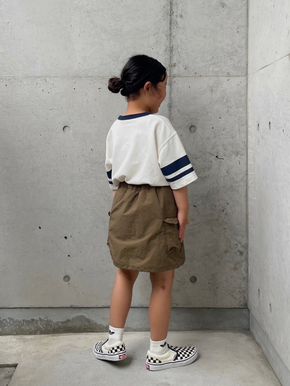 グリーン系のスカート、ブラック系のスリッポン、グリーン系のTシャツ/カットソーを着用したキッズの夏コーディネートの5枚目の写真