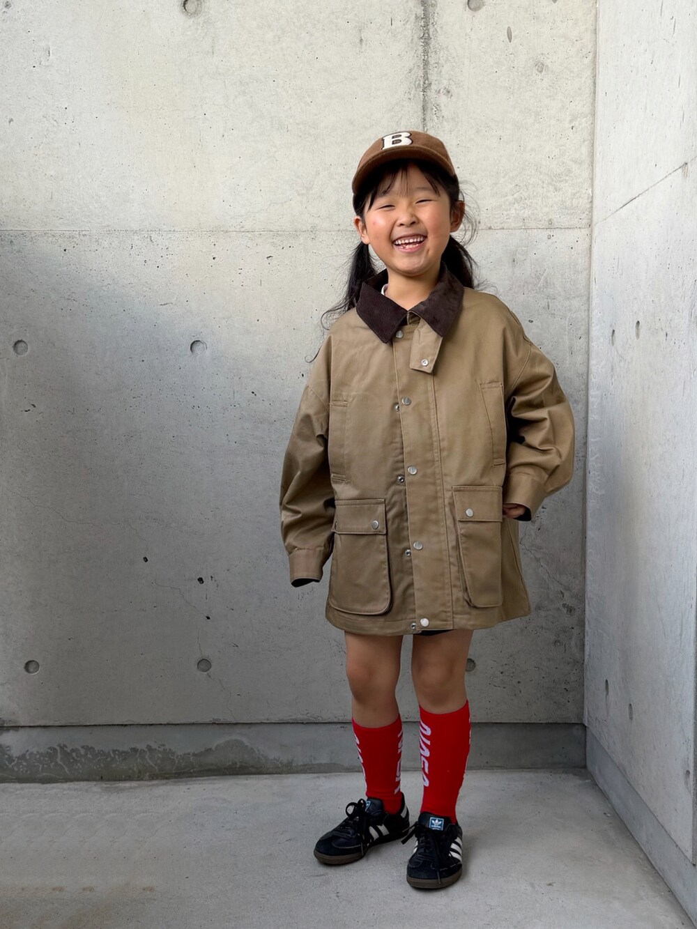 ブラック系のスニーカー、ホワイト系のTシャツ/カットソー、ベージュ系のミリタリージャケットを着用したキッズの秋コーディネートの5枚目の写真