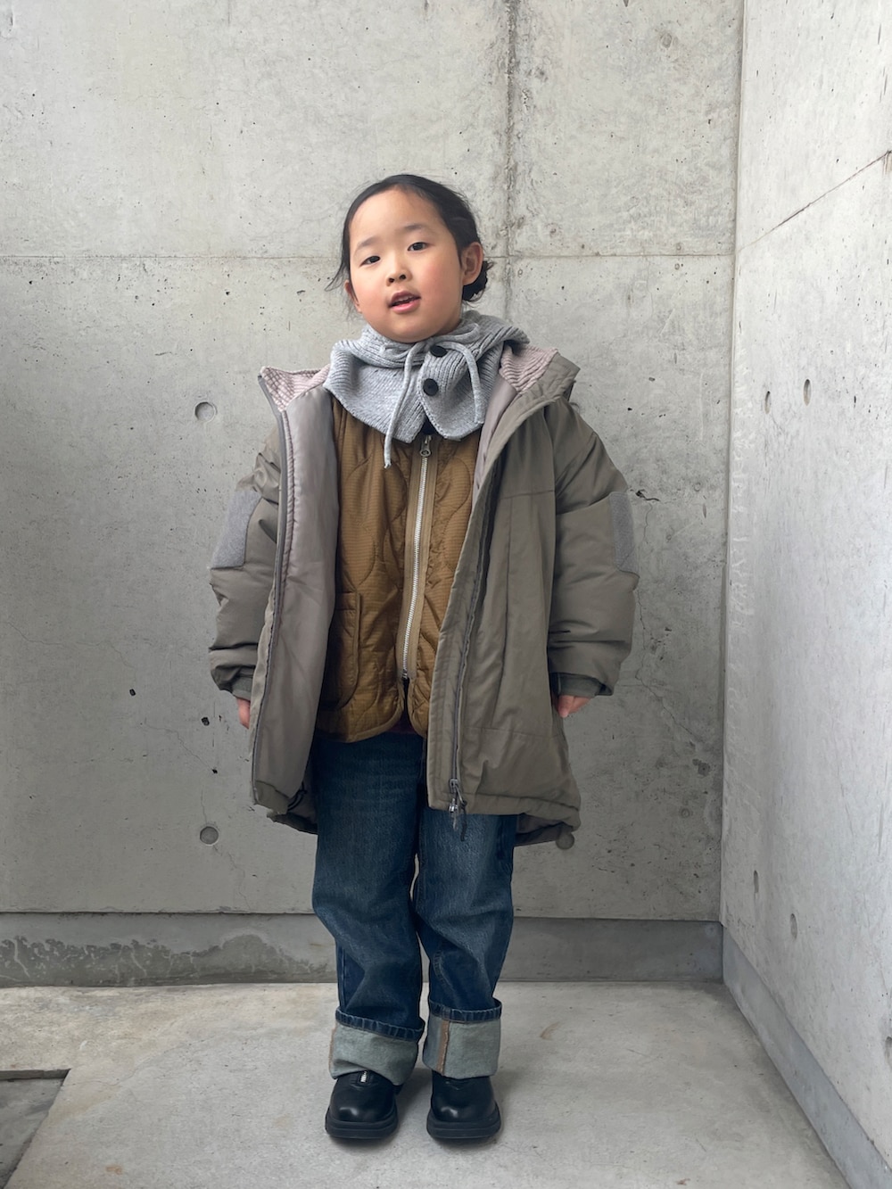 レッド系のスウェット、グリーン系のブルゾン、ブラウン系のダウンジャケット/コートを着用したキッズの冬コーディネートの2枚目の写真