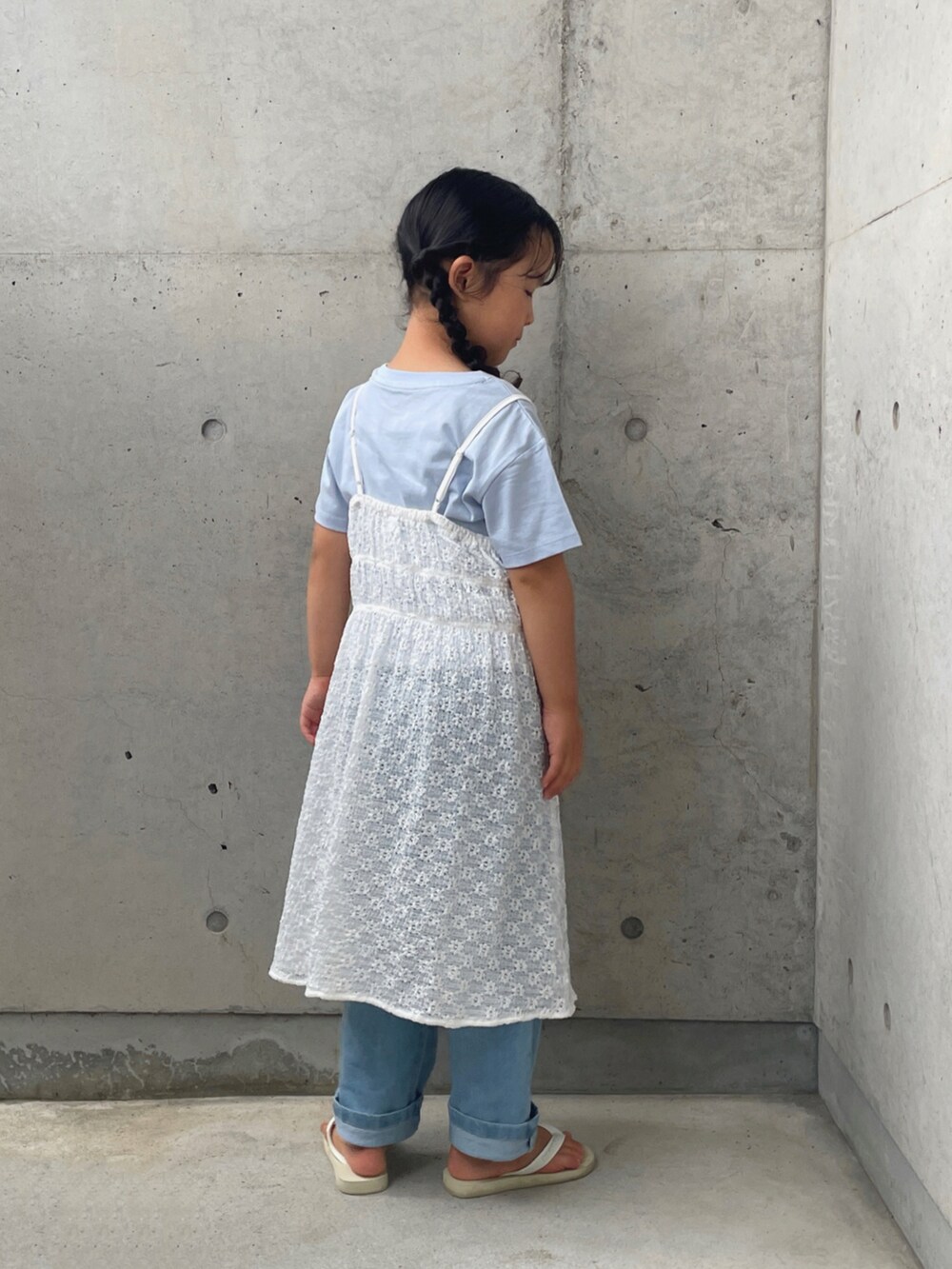 ブルー系のデニムパンツ、ホワイト系のサンダル、ホワイト系のワンピース/ドレスを着用したキッズの夏コーディネートの3枚目の写真