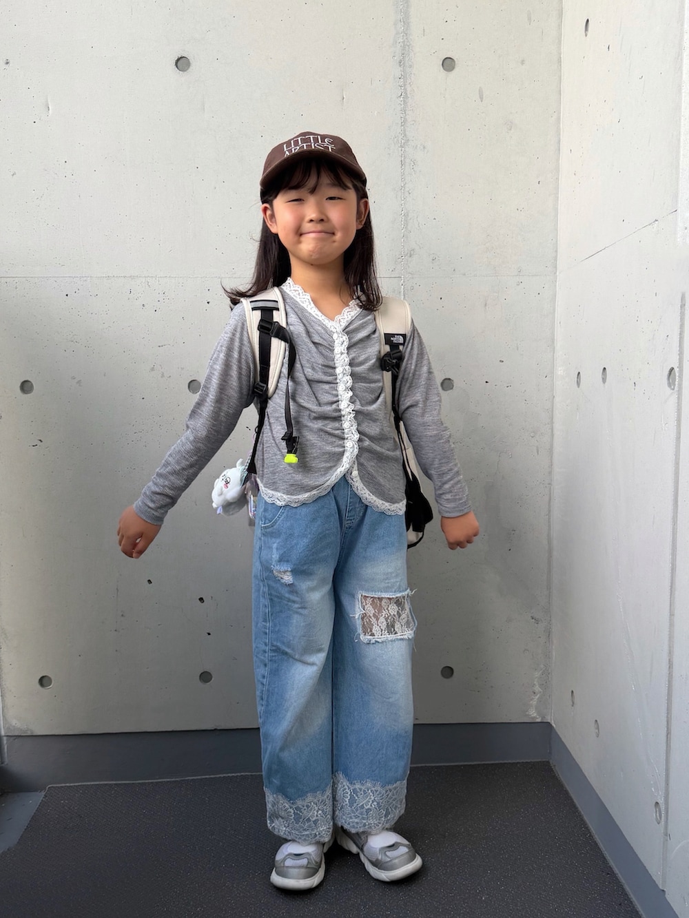 グレー系のTシャツ/カットソー、シルバー系のスニーカー、ブルー系のパンツを着用したキッズの秋コーディネートの3枚目の写真