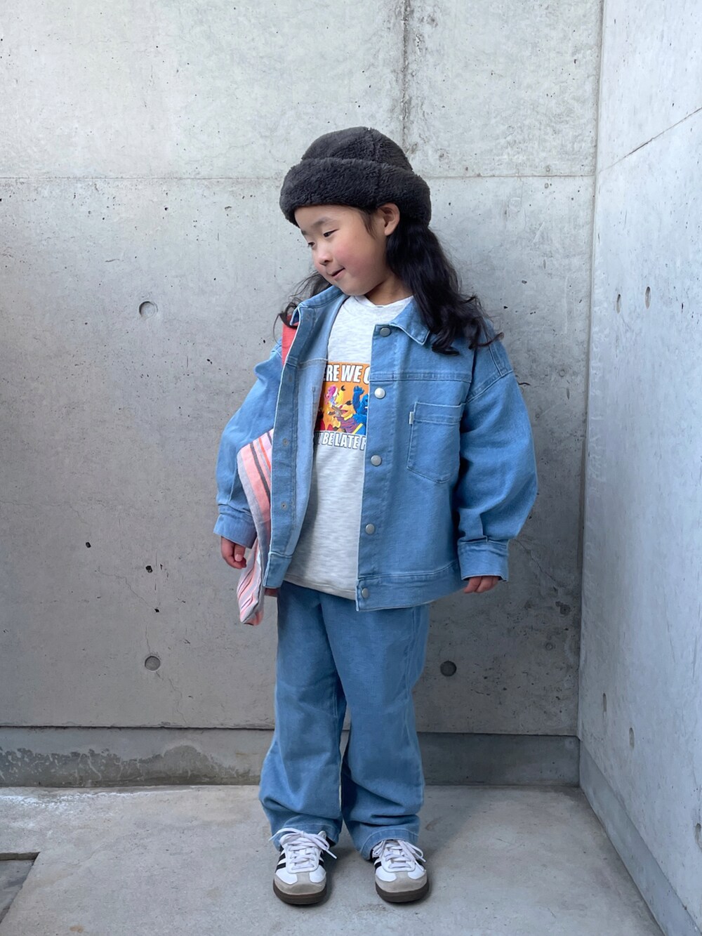 ブルー系のデニムジャケット、オレンジ系のトートバッグ、グレー系のスウェットを着用したキッズの冬コーディネートの5枚目の写真