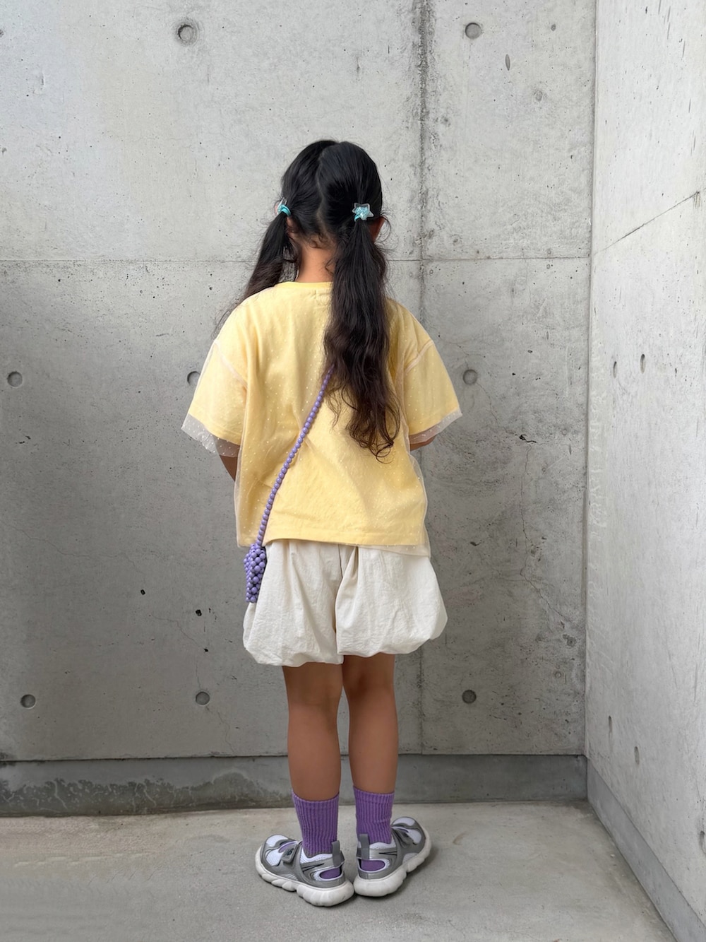 イエロー系のTシャツ/カットソー、ホワイト系のその他パンツ、シルバー系のスニーカーを着用したキッズの春コーディネートの4枚目の写真