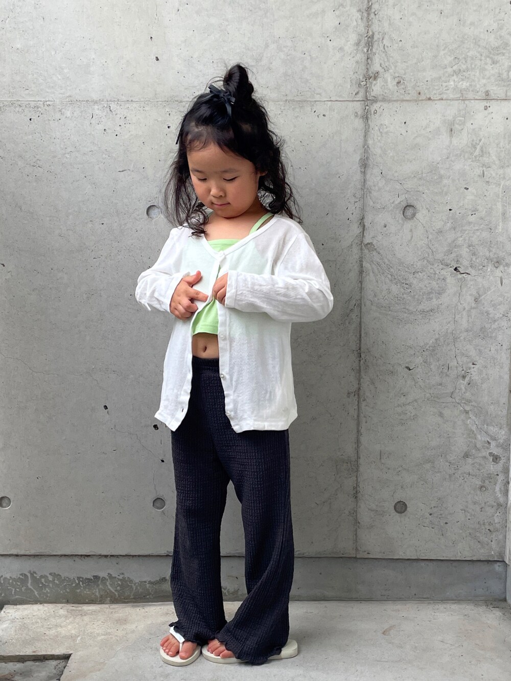 グリーン系のキャミソール、グレー系のその他パンツ、ホワイト系のサンダルを着用したキッズの夏コーディネートの5枚目の写真