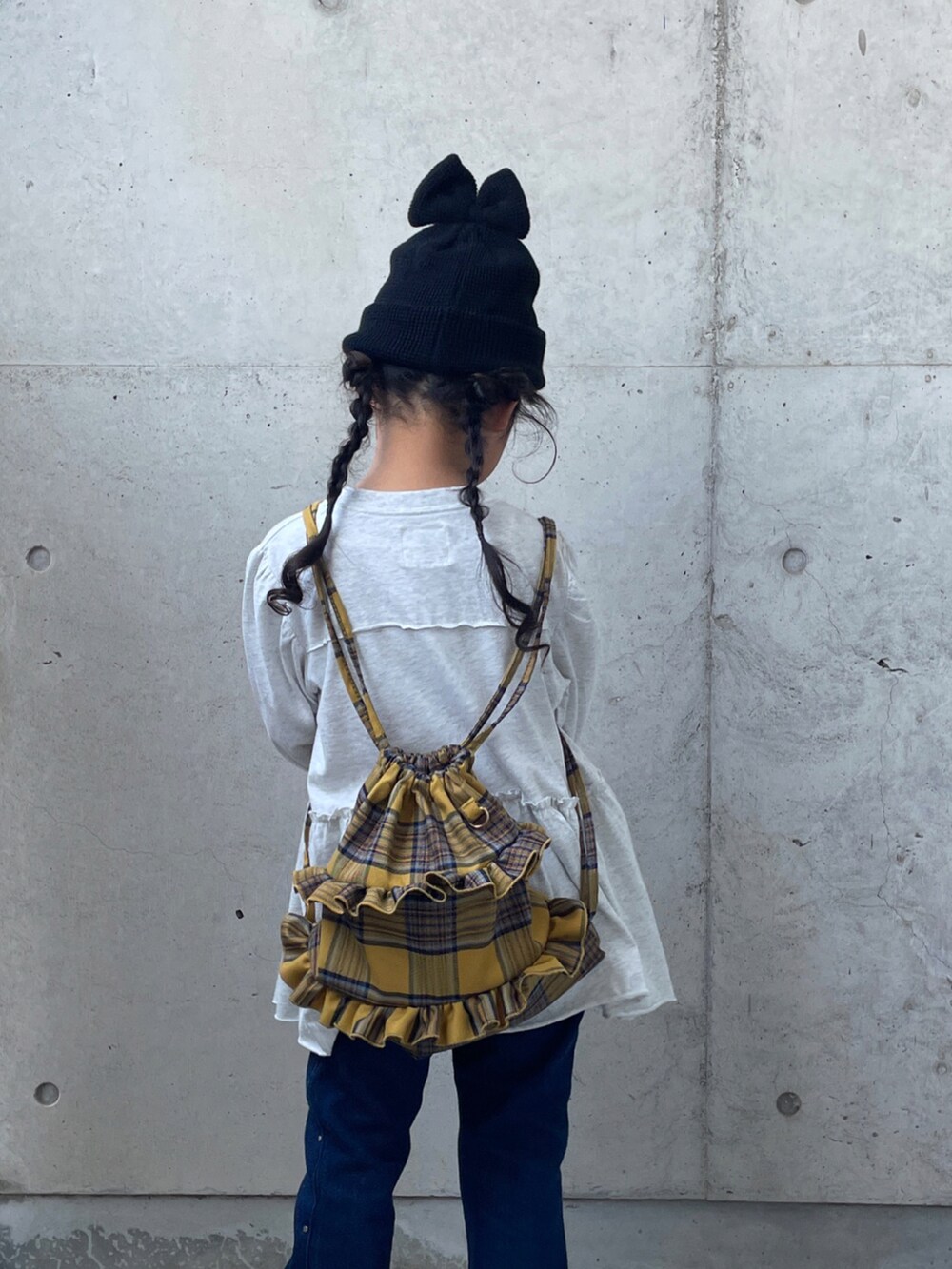 ブルー系のデニムパンツ、グレー系のワンピース、イエロー系のバックパック/リュックを着用したキッズの夏コーディネートの5枚目の写真