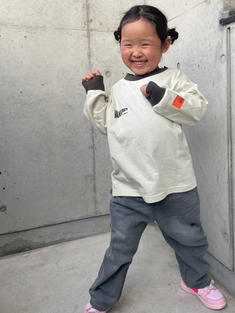 ベージュ系のTシャツ/カットソー、グレー系のデニムパンツ、ピンク系のスニーカーを着用したキッズの春コーディネートの3枚目の写真