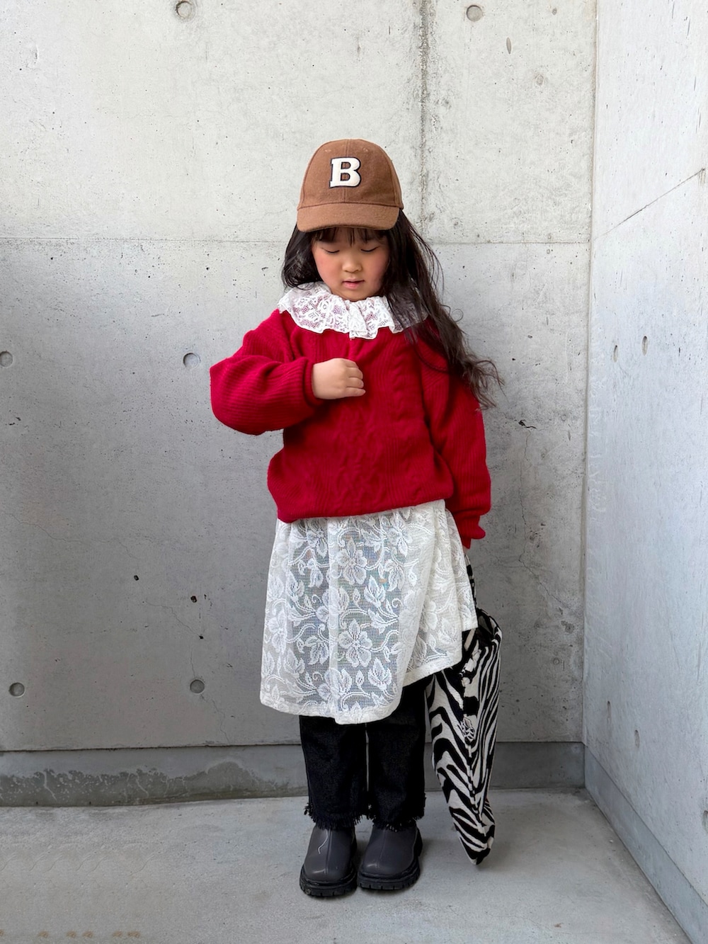 ベージュ系のスウェット、グレー系のブーツ、レッド系のニット/セーターを着用したキッズの冬コーディネートの5枚目の写真