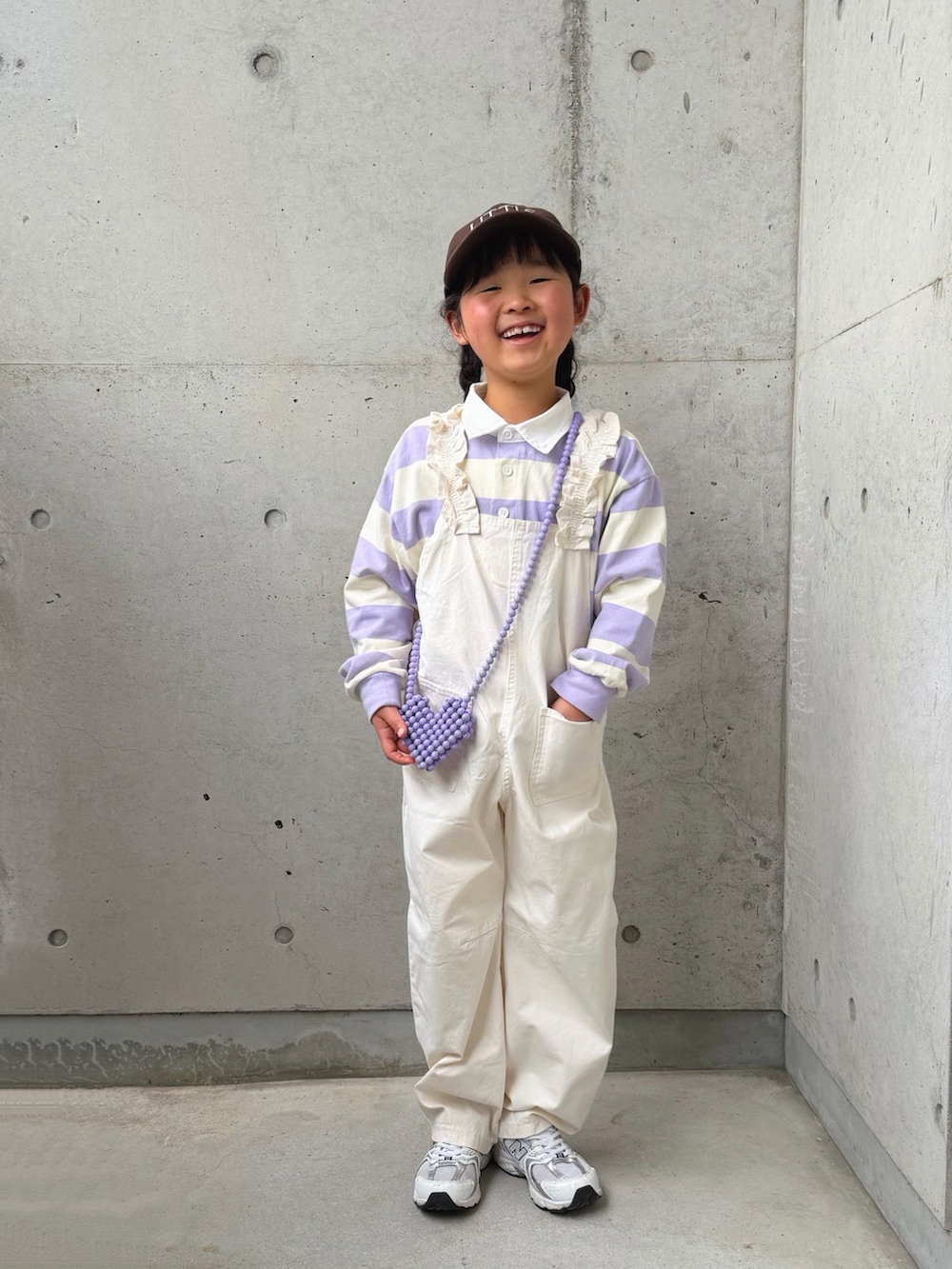 パープル系のTシャツ/カットソー、ホワイト系のサロペット/オーバーオール、ホワイト系のスニーカーを着用したキッズの春コーディネートの4枚目の写真