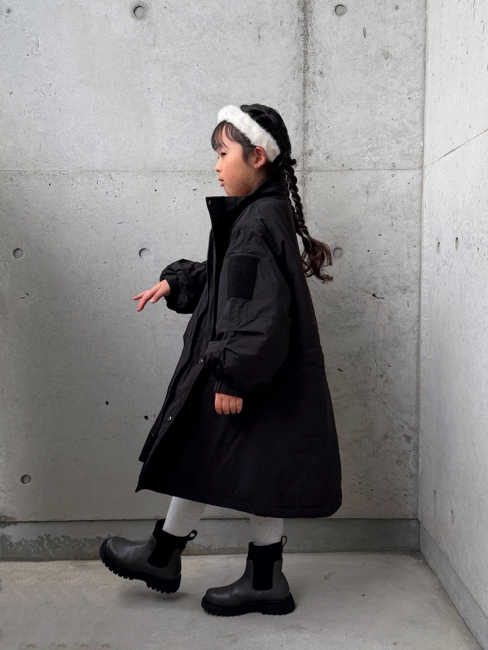 ブラック系のミリタリージャケット、ブラック系のその他パンツ、グレー系のブーツを着用したキッズの冬コーディネートの2枚目の写真