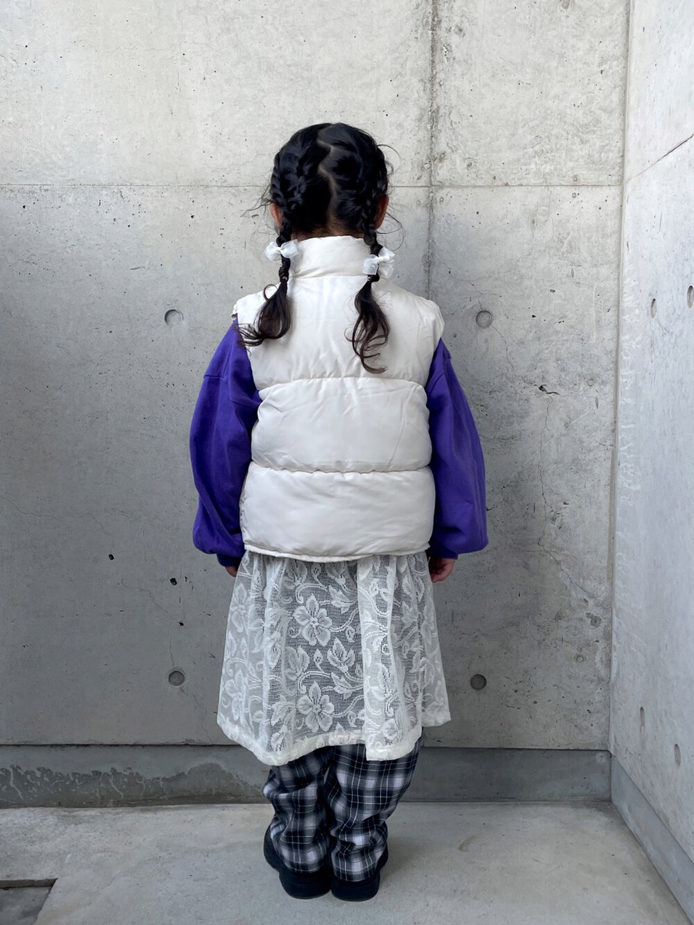 ホワイト系のスカート、パープル系のTシャツ/カットソー、ブラック系のブーツを着用したキッズの冬コーディネートの3枚目の写真