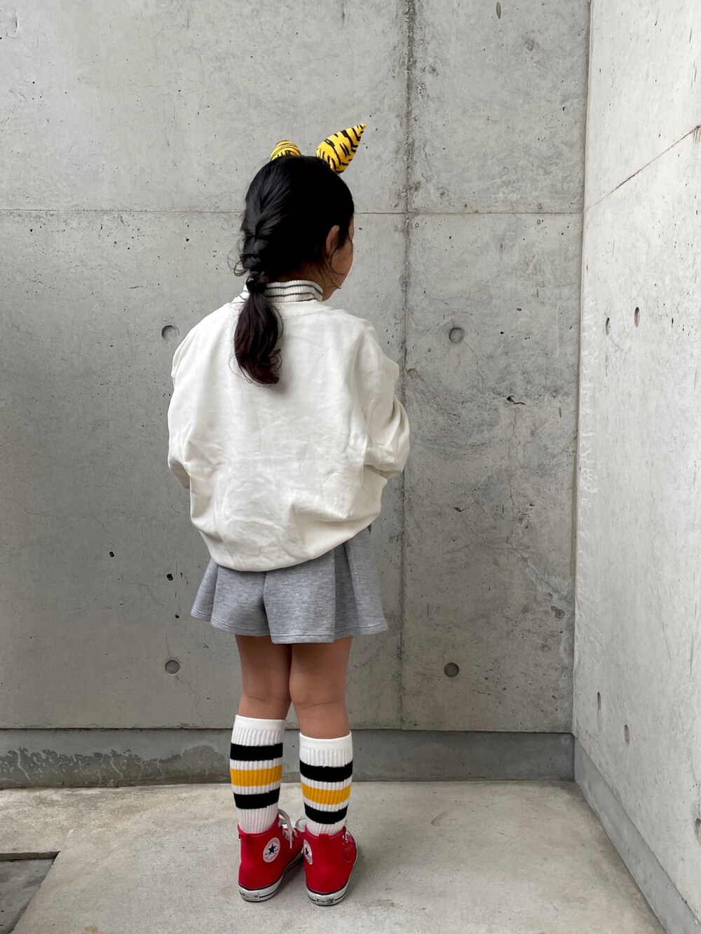 レッド系のスニーカー、ホワイト系のTシャツ/カットソー、ホワイト系のスウェットを着用したキッズの冬コーディネートの4枚目の写真