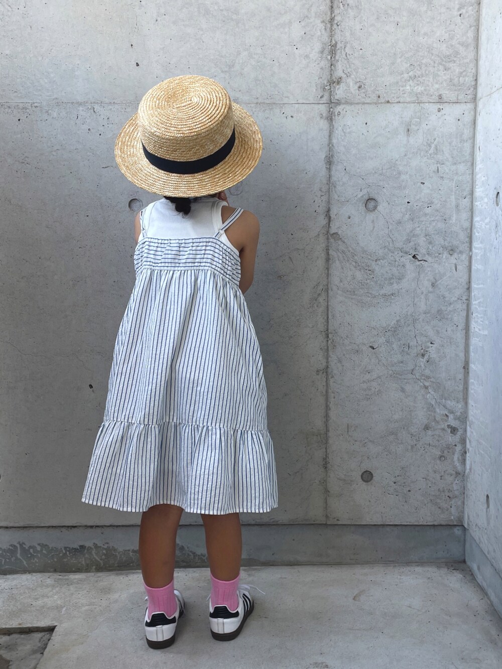 ホワイト系のワンピース/ドレス、ホワイト系のスニーカー、ブラック系のバックパック/リュックを着用したキッズの夏コーディネートの3枚目の写真