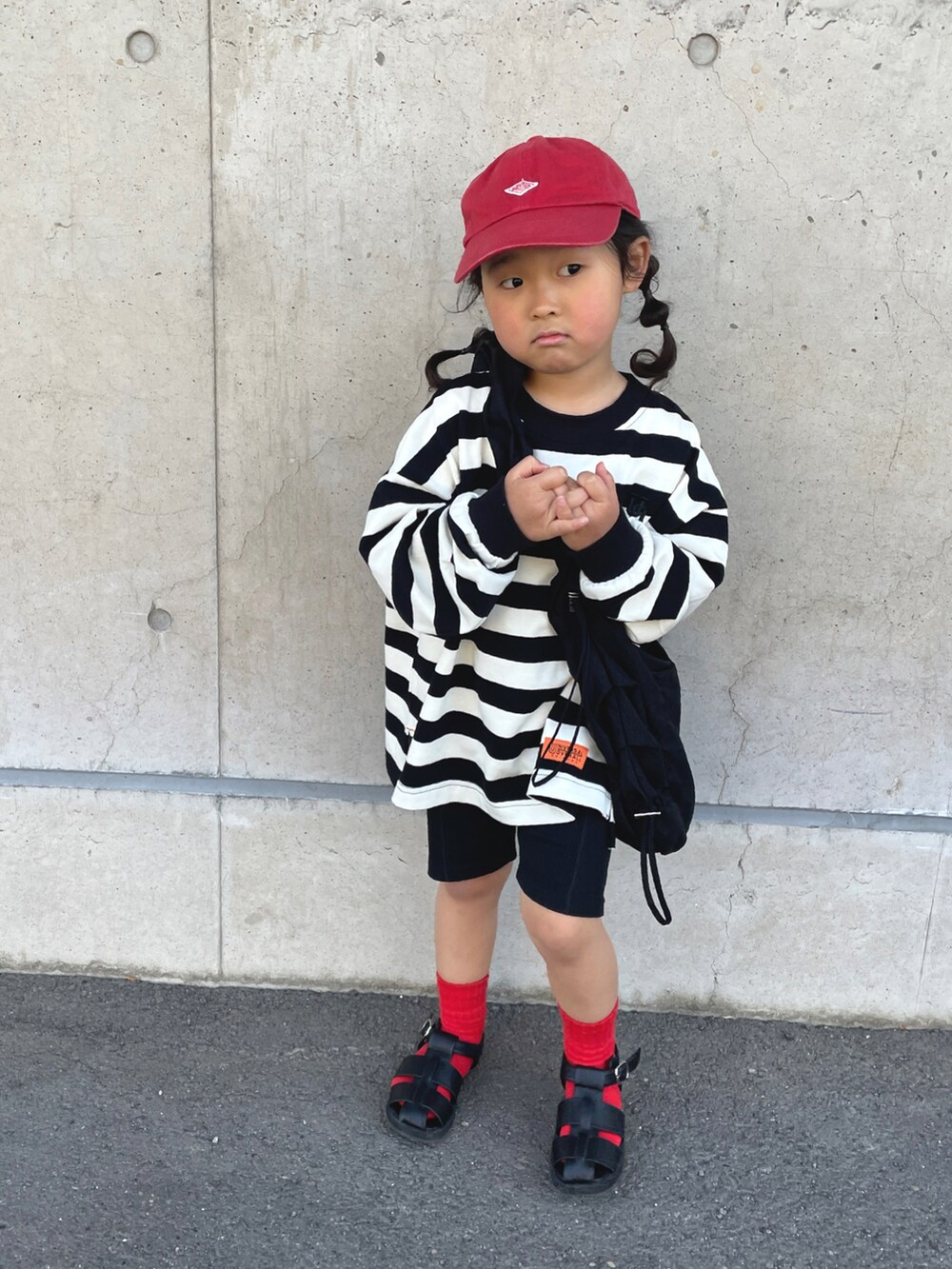 ブラック系のTシャツ/カットソー、ブラック系のショルダーバッグ、ブラック系のサンダルを着用したキッズの春コーディネートの2枚目の写真