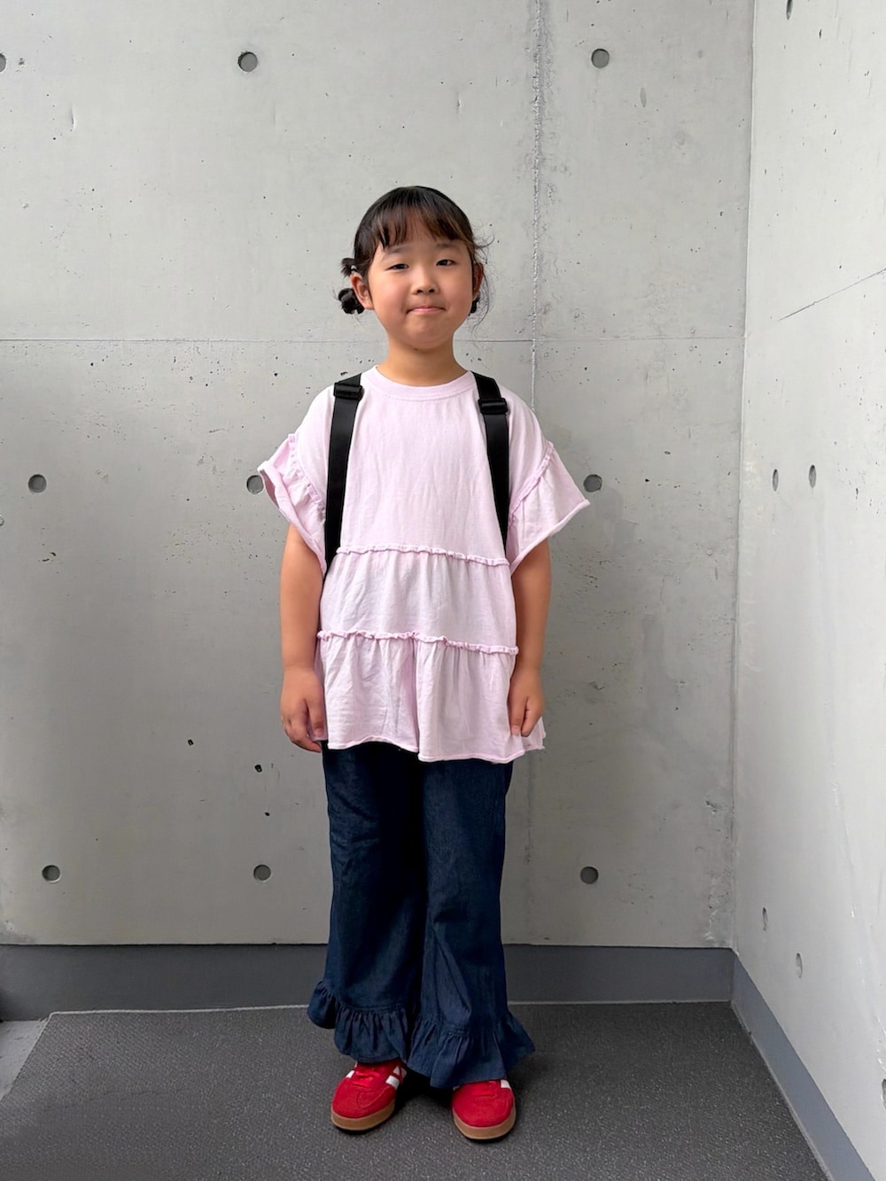 ブルー系のデニムパンツ、ピンク系のTシャツ/カットソー、レッド系のスニーカーを着用したキッズの秋コーディネートの3枚目の写真
