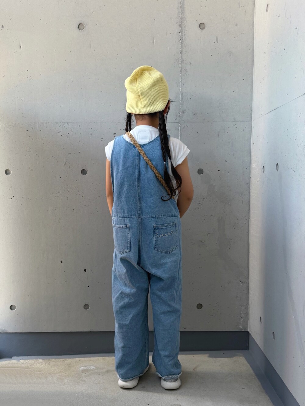 ブルー系のサロペット/オーバーオール、ベージュ系のショルダーバッグ、シルバー系のスニーカーを着用したキッズの夏コーディネートの4枚目の写真