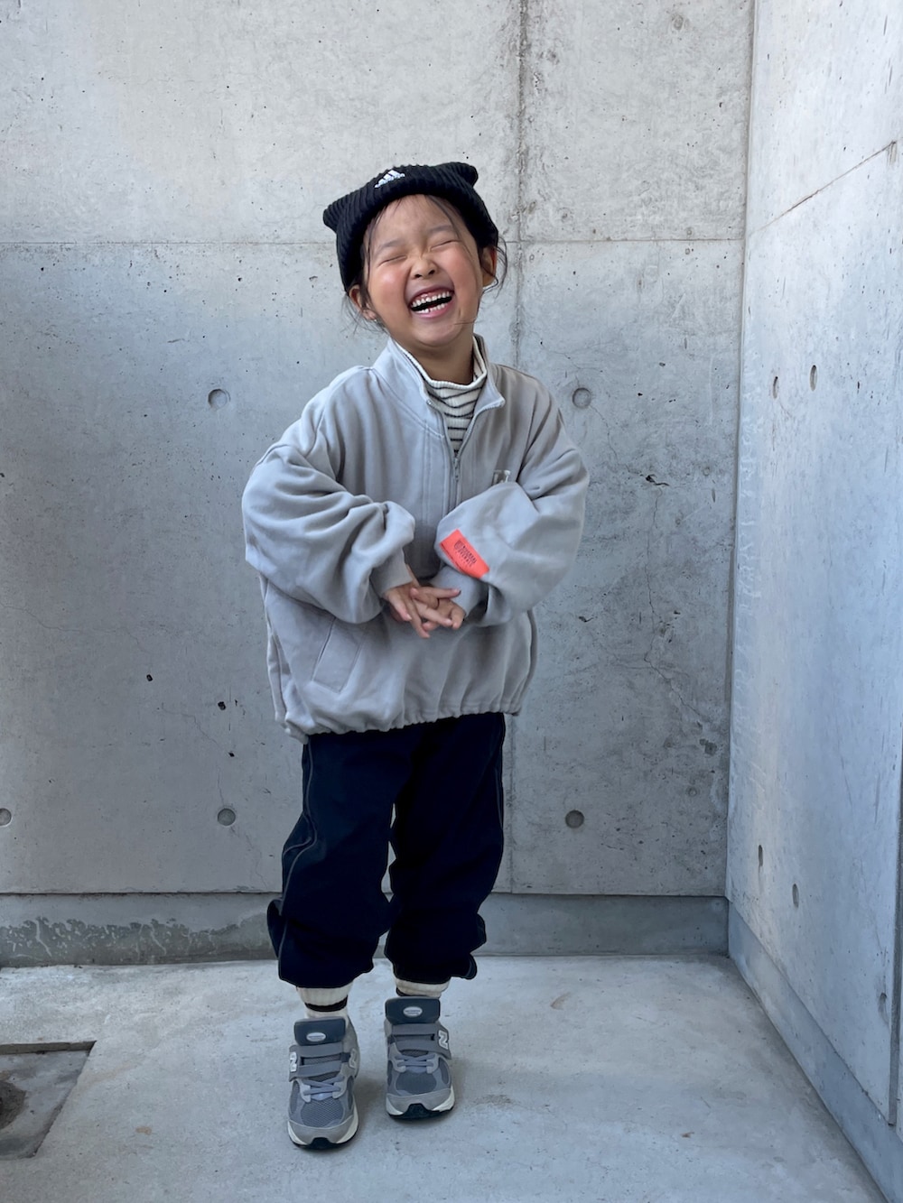 ブラック系のパンツ、ホワイト系のトップス、グレー系のスウェットを着用したキッズの冬コーディネートの5枚目の写真