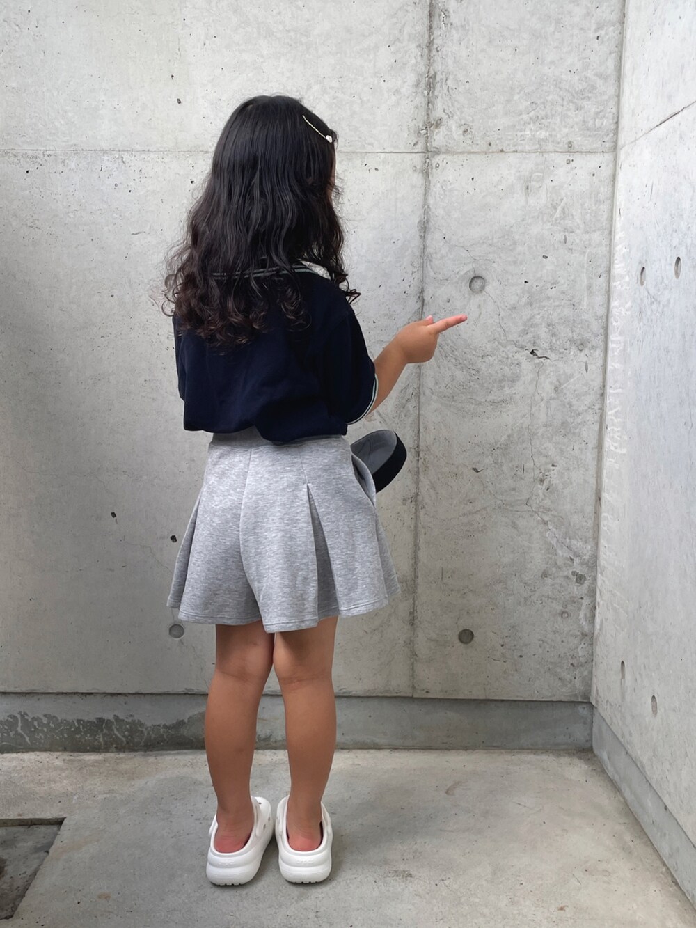 ホワイト系のサンダル、ブルー系のポロシャツ、グレー系のスカートを着用したキッズの夏コーディネートの4枚目の写真