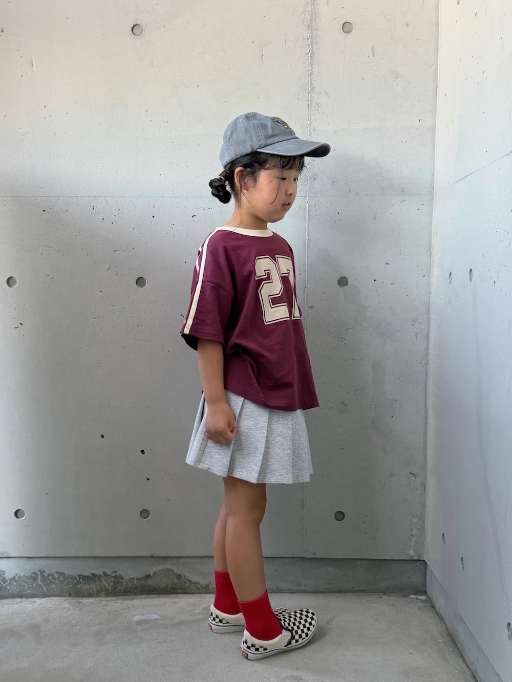 レッド系のTシャツ/カットソー、ブラック系のスリッポン、グレー系のスカートを着用したキッズの夏コーディネートの5枚目の写真