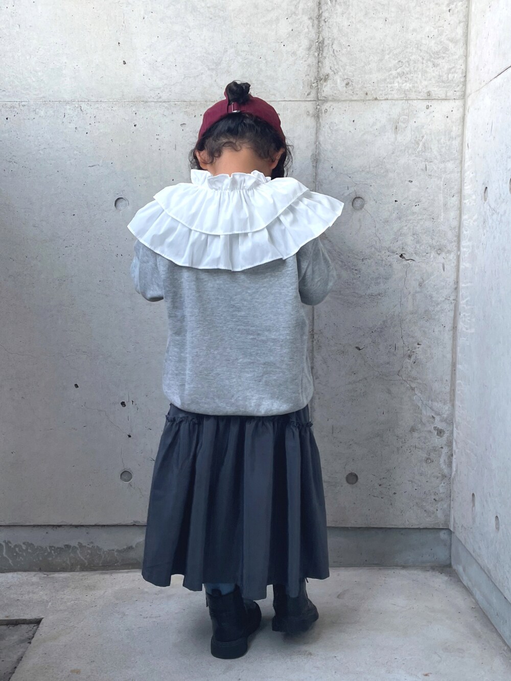 グレー系のワンピース、ブラック系のブーツ、グレー系のトップスを着用したキッズの秋コーディネートの4枚目の写真