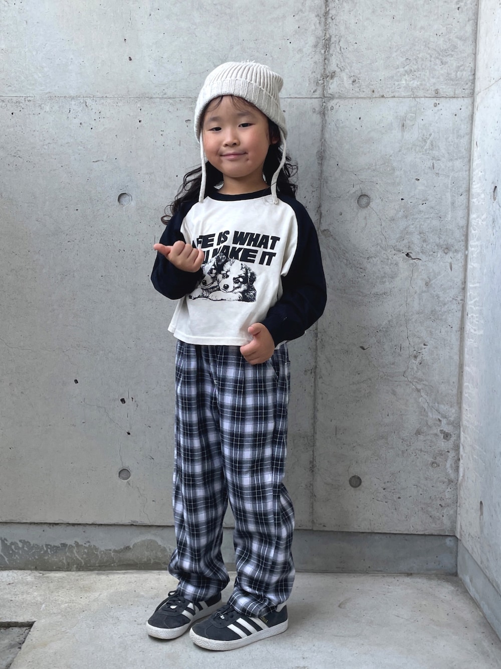 ブラック系のスニーカー、ブラック系のパンツ、ホワイト系のトップスを着用したキッズの秋コーディネートの3枚目の写真