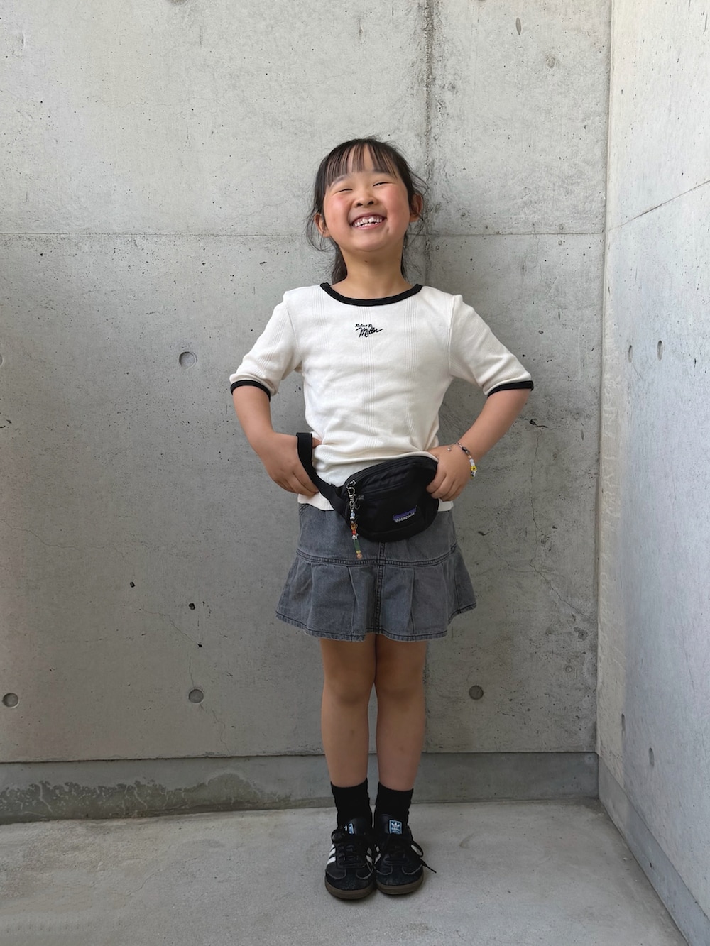 ブラック系のボディバッグ/ウエストポーチ、ホワイト系のTシャツ/カットソー、グレー系のスカートを着用したキッズの春コーディネートの4枚目の写真