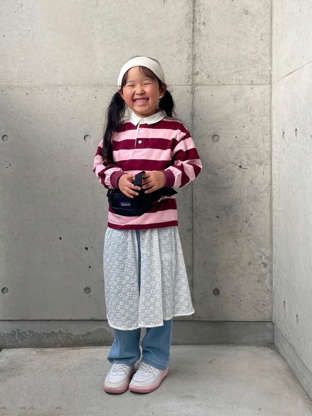 ブラック系のボディバッグ/ウエストポーチ、ピンク系のTシャツ/カットソー、ホワイト系のスニーカーを着用したキッズの秋コーディネートの4枚目の写真