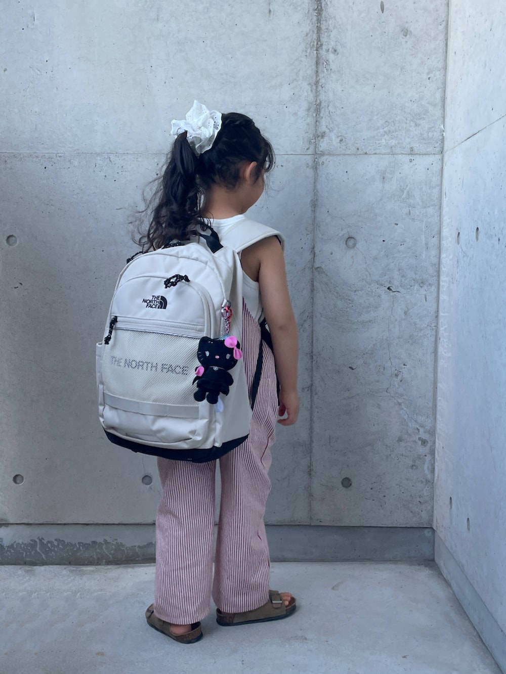 ホワイト系のシャツ/ブラウス、レッド系のオールインワン・サロペット、ホワイト系のバックパック/リュックを着用したキッズの秋コーディネートの2枚目の写真