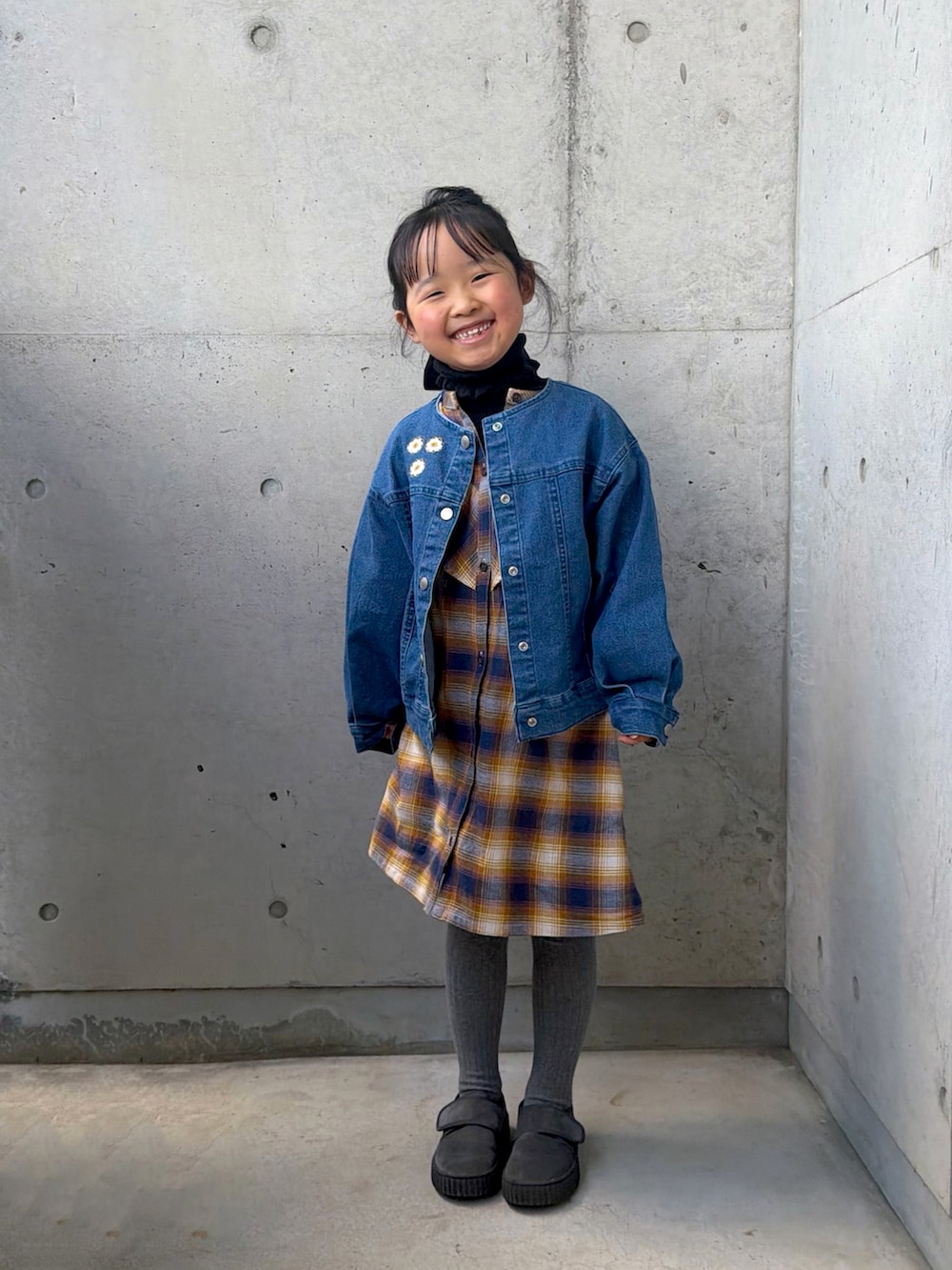 イエロー系のワンピース、グレー系のその他シューズ、ブラック系のニット/セーターを着用したキッズの冬コーディネートの5枚目の写真