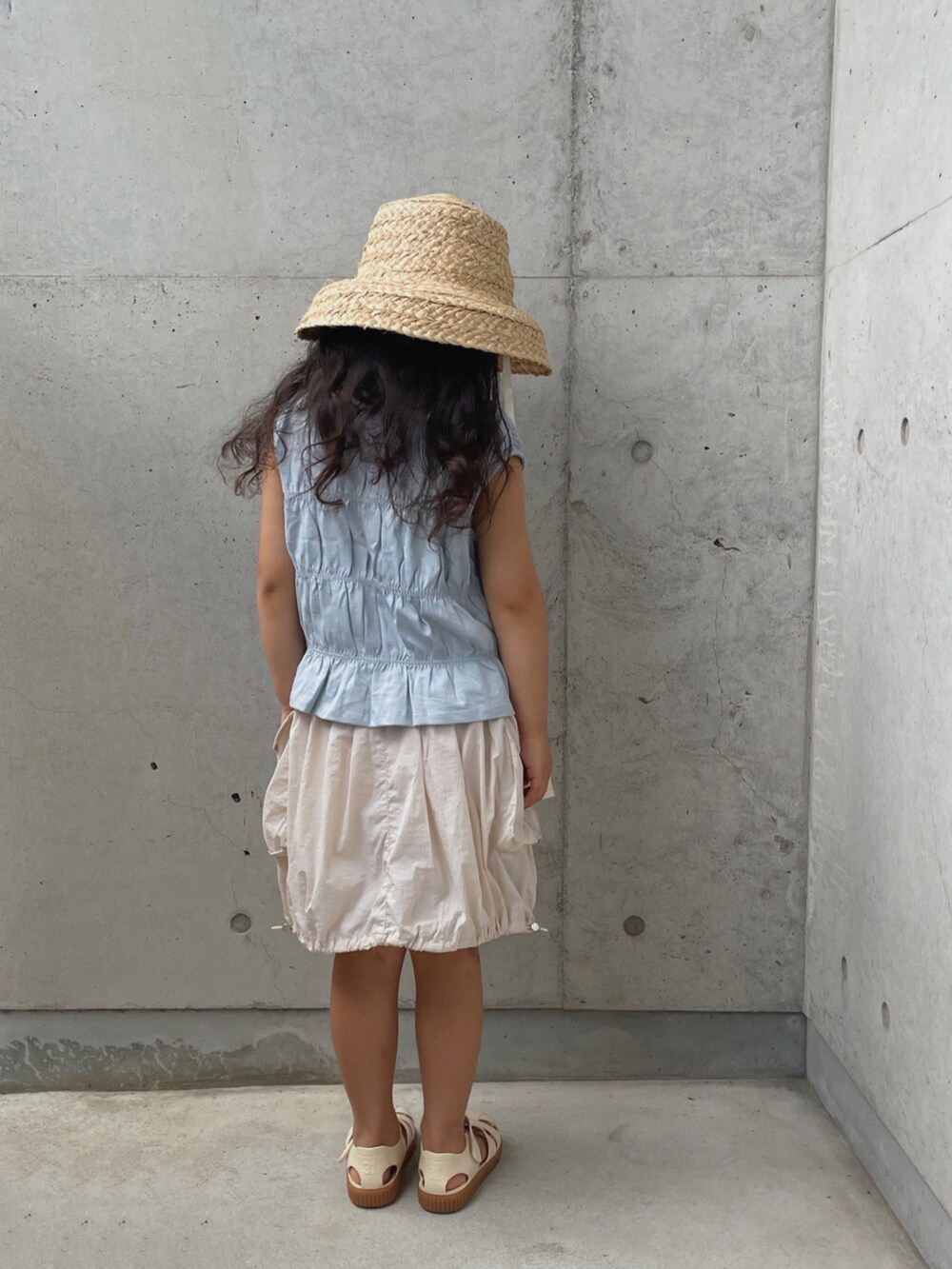 ホワイト系のサンダル、ホワイト系のスカート、ブルー系のトップスを着用したキッズの夏コーディネートの4枚目の写真