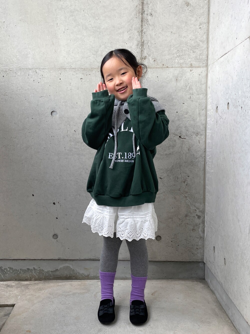 グリーン系のトップス、ホワイト系のパンツ、ブラック系のその他シューズを着用したキッズの冬コーディネートの4枚目の写真