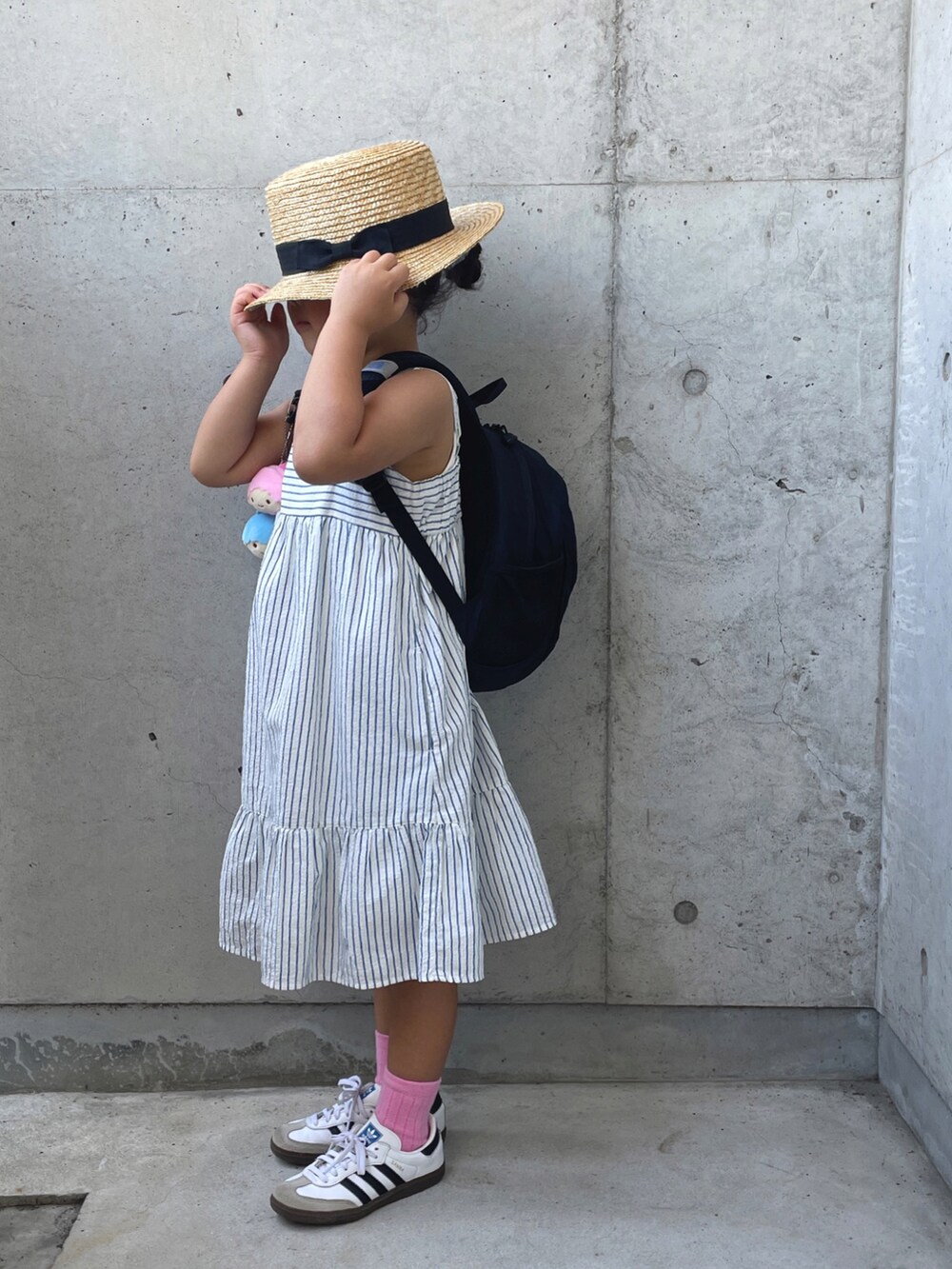 ホワイト系のワンピース/ドレス、ホワイト系のスニーカー、ブラック系のバックパック/リュックを着用したキッズの夏コーディネートの4枚目の写真