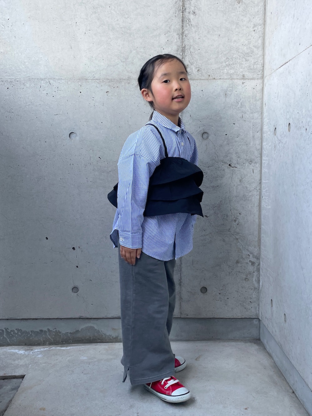 「シャツスタイル、ストライプシャツ、ビスチェ、スウェットパンツ、ハイカットスニーカー、キッズコーデ」｜「CONVERSEのconverse コンバース CHILD ALL STAR N Z HI キッズスニーカー(チャイルドオールスターNZHI)（スニーカー、レッド系）」を使った、ioooさん（キッズ・110cm）の春コーディネートの2枚目の写真