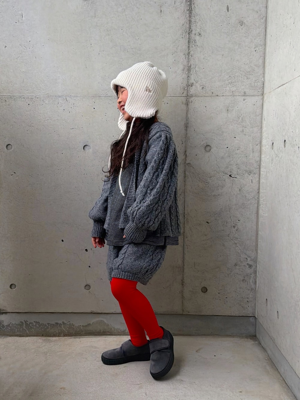 グレー系のニット/セーター、グレー系のその他パンツ、ブラック系のTシャツ/カットソーを着用したキッズの冬コーディネートの3枚目の写真