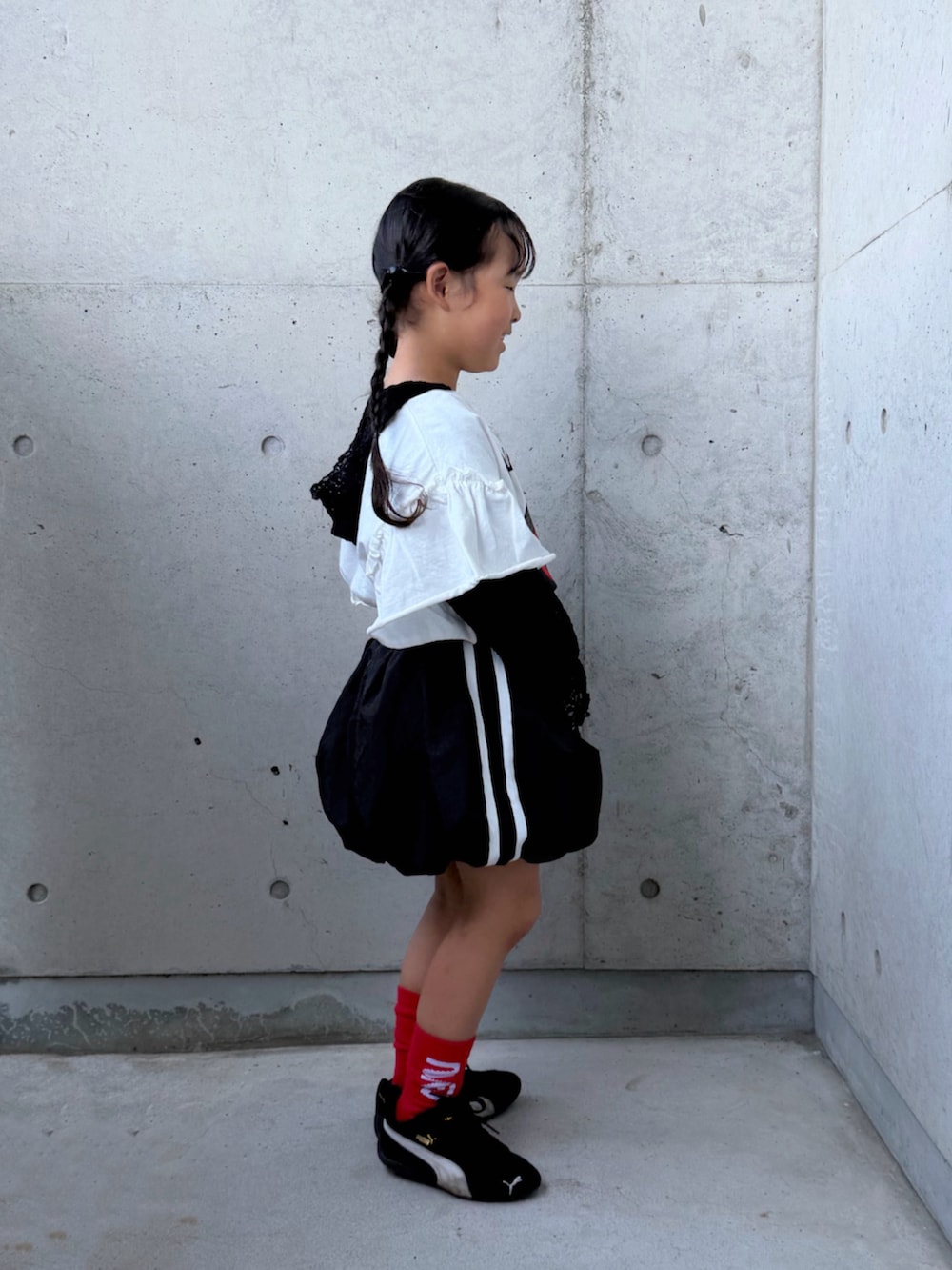 ホワイト系のTシャツ/カットソー、ブラック系のTシャツ/カットソー、ブラック系のスカートを着用したキッズの秋コーディネートの2枚目の写真