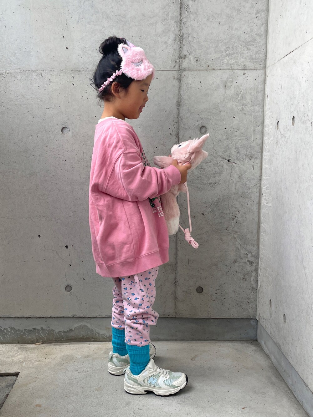 ピンク系のスウェット、ピンク系のその他パンツ、ホワイト系のスニーカーを着用したキッズの秋コーディネートの2枚目の写真