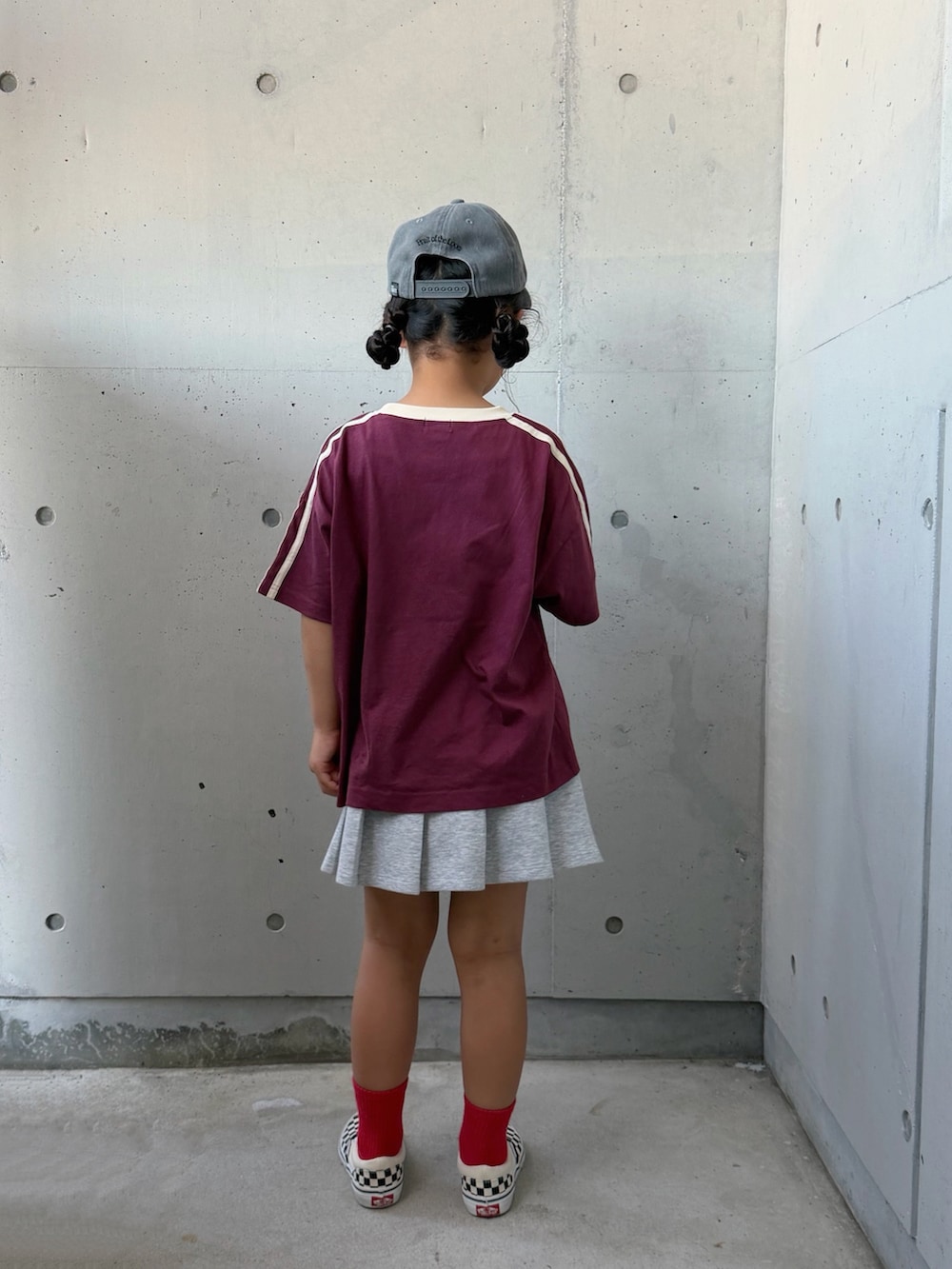 レッド系のTシャツ/カットソー、ブラック系のスリッポン、グレー系のスカートを着用したキッズの夏コーディネートの3枚目の写真