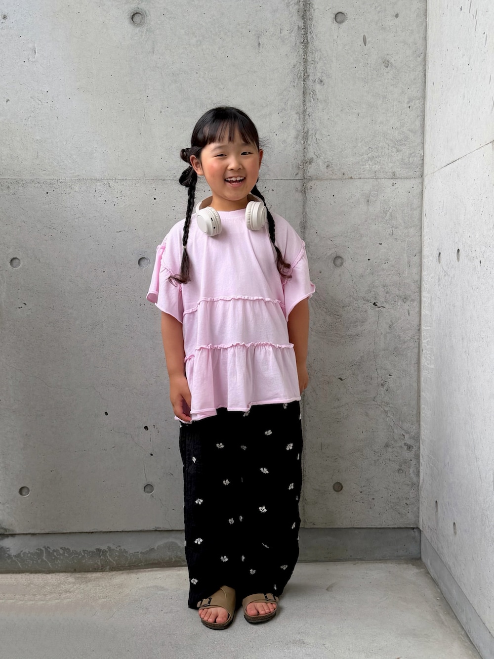 ピンク系のTシャツ/カットソー、ブラック系のその他パンツ、ベージュ系のサンダルを着用したキッズの春コーディネートの4枚目の写真